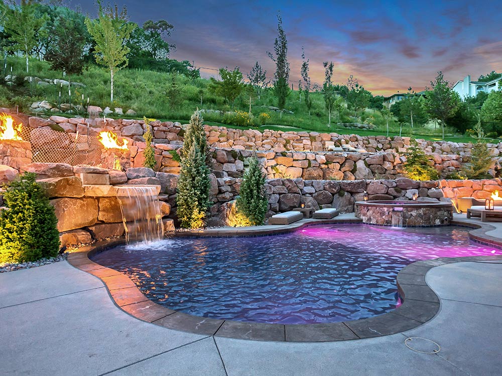 Rock water feature, rock hot tub, swimming pool, stone terraced wall and fire pit